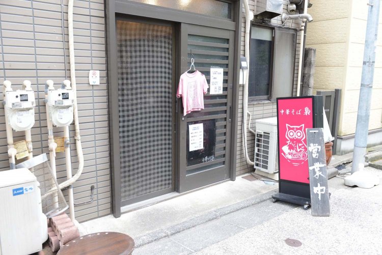 ピンクの看板とTシャツが印象的。Tシャツは元々えんじ色だったが、日に焼けてこの色になったという。