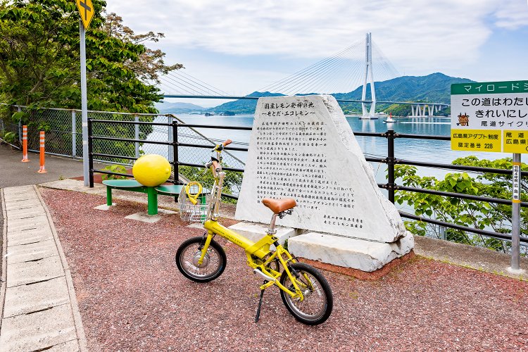 国産レモン発祥の地の碑。周囲にはレモン畑が広がっている。ここから眺める多々羅大橋もいい。