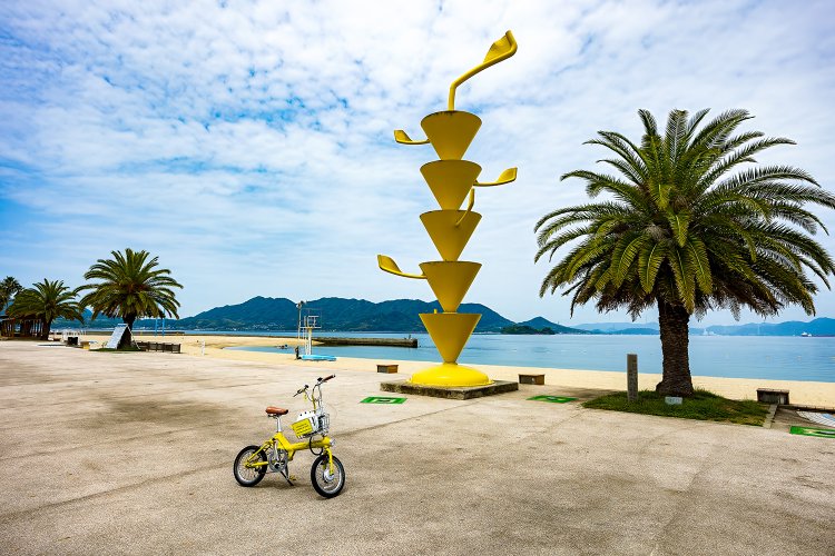 レストランと売店のある建物を抜けてビーチに入ってすぐに目に飛び込んでくるトロピカルなアート作品。眞板雅文「空へ」。レモンの妖精かな?!