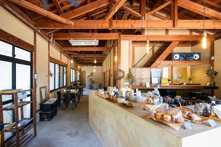 土壁や土間、梁や柱は倉庫だったころのまま。テーブルとテーブルの間隔も広く、 ゆったり落ち着いた雰囲気の店内。