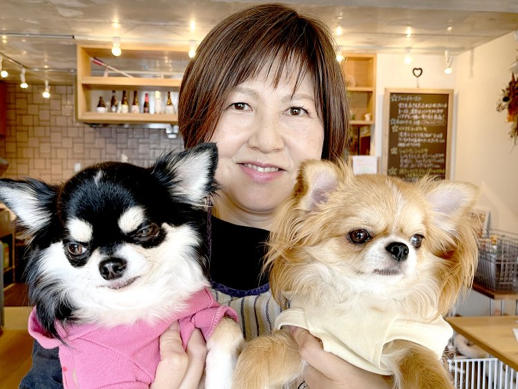 愛犬のノワールちゃん（左）とコロンちゃん（右）を抱く吉橋さん。