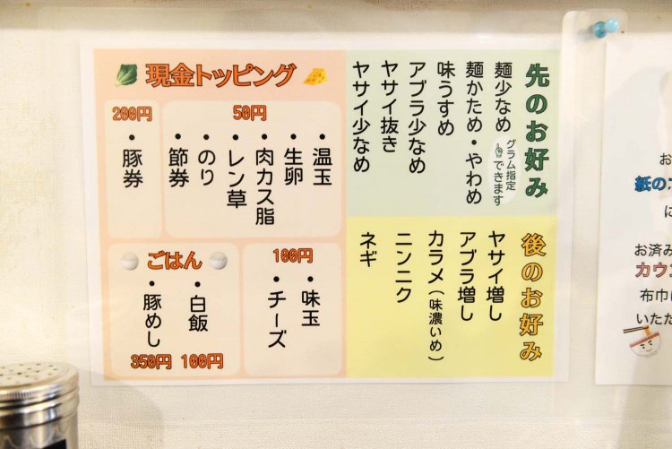 壁面やテーブル周りに「お好み」やトッピングのメニューが掲示されている。