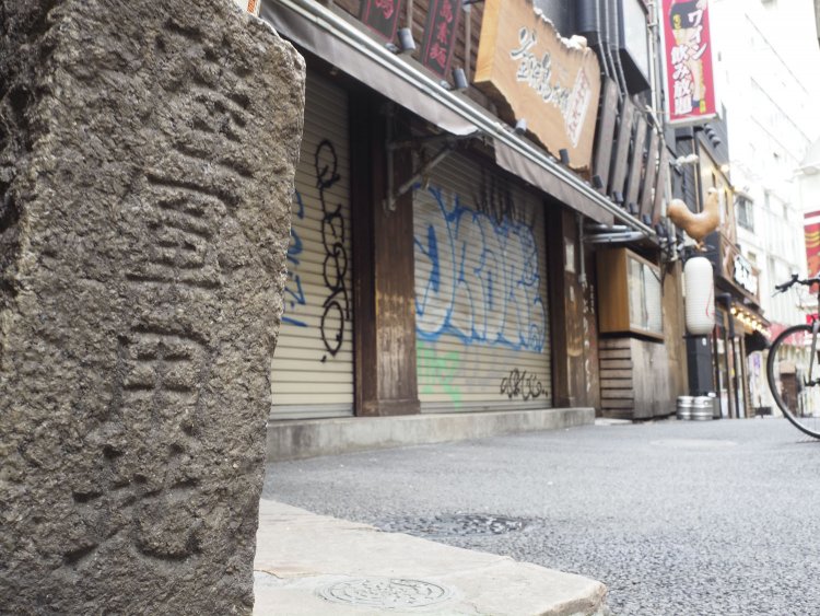 近づいてみると「陸軍用地」の文字がはっきりと。戦後ずっとこの場所にあって様々な人々の喜怒哀楽を見つめてきたことだろう。背後がすぐガールズバーなのも、繁華街に残された旧軍の施設を表している。