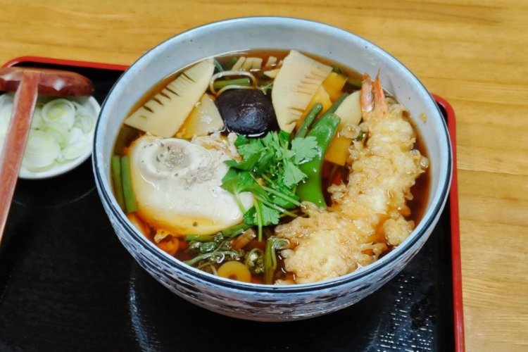 山菜やエビ天、煮卵などの具材を惜しみなく盛り付けた地獄そば1200円。
