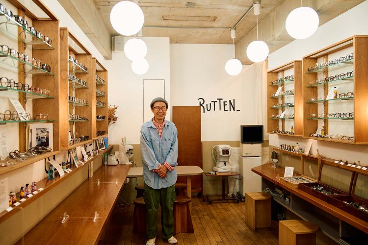 地元っ子の店主・荒岡敬さん。両壁に眼鏡棚とテーブルが配される。