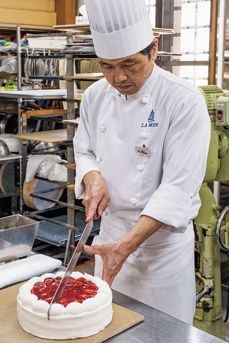 卵白を用いたふんわりスポンジにイチゴとジャムを添えたラ メール（1ピース510円）をスッと切り分ける大関博之さん。