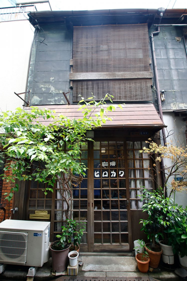 路地に立つ長屋の一軒。こんもり茂る植栽が標だ。