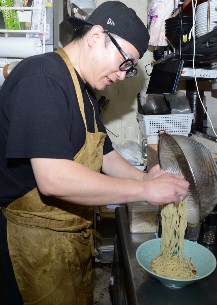 しっかりと締めた麺を盛り付ける店主。