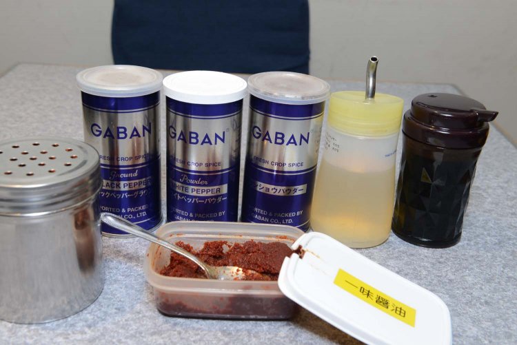 ズラリと並んだ卓上の調味料。店オリジナルの一味醤油を入れれば辛味で味が引き締まる。