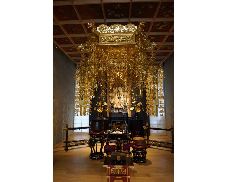 7階本堂の黒漆喰磨き壁は、左官職人の久住有生氏によるもの。檀家である故・内田君子氏作の鮮やかな天井絵は旧本堂から引き継がれ、壁との美しいコントラストを成している。