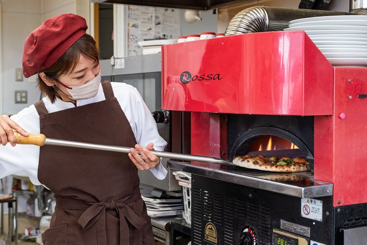 500℃の高温で一気に焼き上げる店主の小屋麻理子さん。