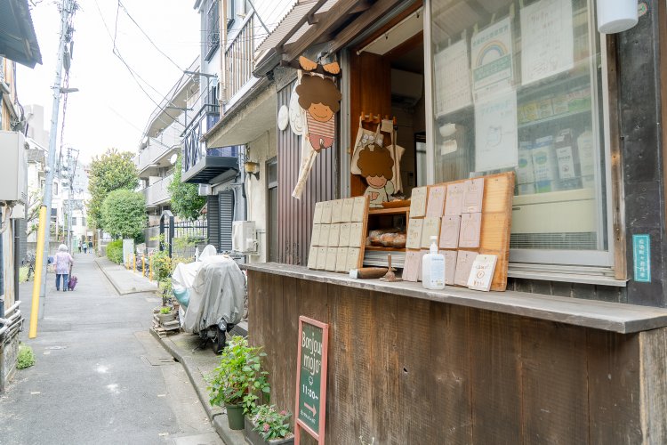 窓の下に板をつけてお店に。中でパンを焼いている。木の札がメニュー一覧だ。