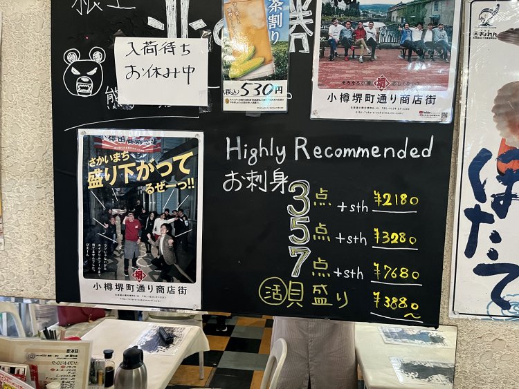 刺し身のメニューを見ながら、その隣にある小樽の商店街のポスターもエモさ100％。