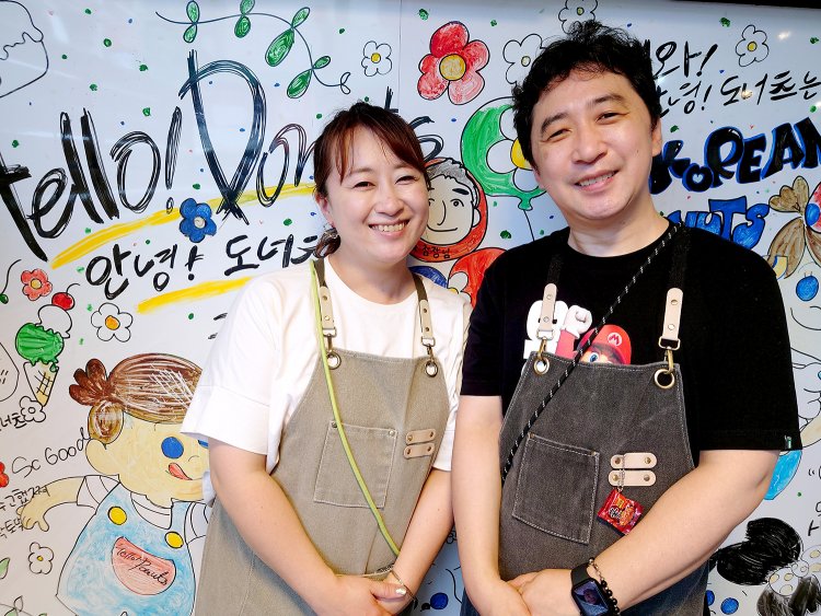 店長のキムシヨンさんと奥さまのかなえさん。スタッフが描いた似顔絵通りの優しい笑顔でいらっしゃいませ！