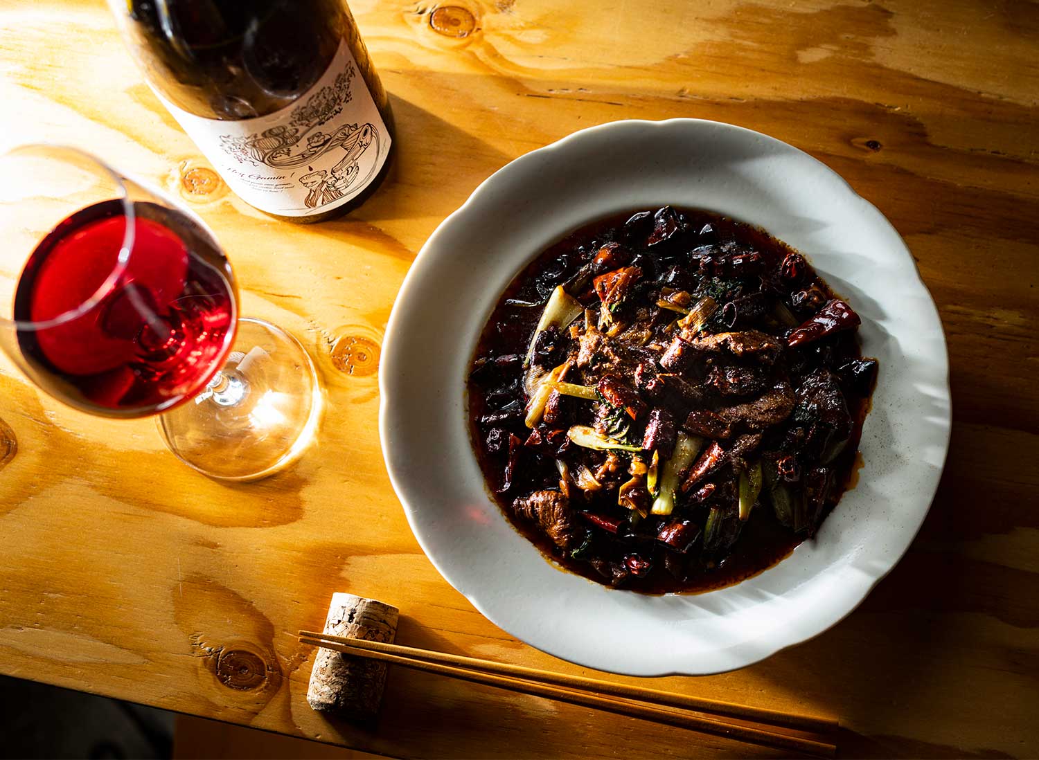 蝦夷鹿の水煮肉片2200円はうまみのある辛さでワインが進む。ワインはボトルのほか、グラスも5種類用意。