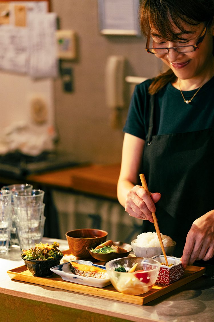 店主の小林さん。焼き鮭などのメインと小さいおかず3種他の定番定食は1320円。