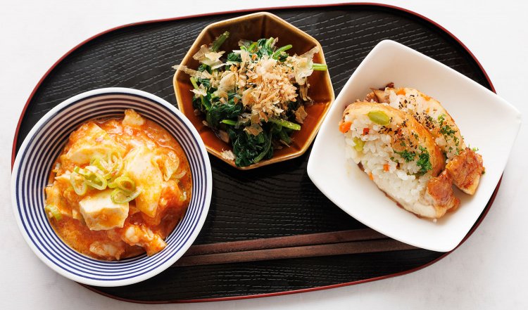 エビチリ豆腐などお晩菜3点盛の一例。右は鶏モモのピラフ詰め。