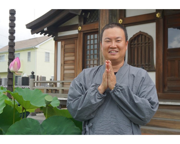 羽田さんが合掌される姿に、蓮のつぼみが重なる。