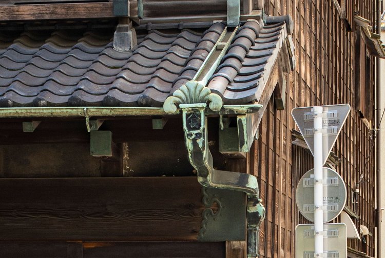 緑青の生えた銅製雨樋とその意匠に、手間を惜しまぬ造作が垣間見える。