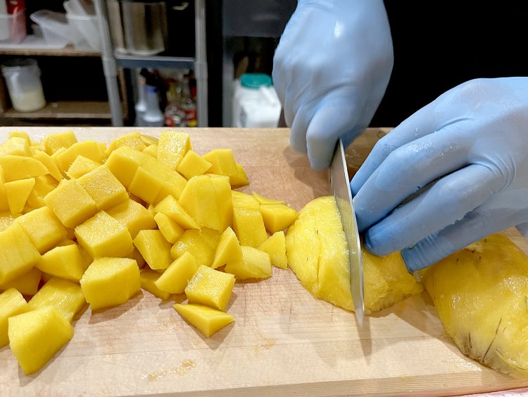 取材中ちょうどマンゴーの仕込みに遭遇。スタッフがひとつずつ皮を剥き、一口大にカットしていく。