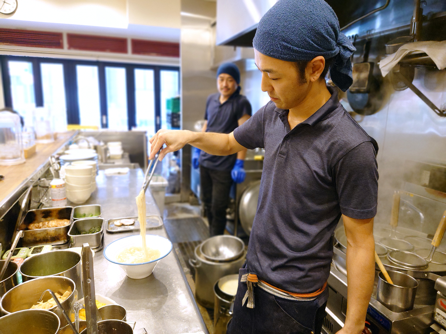 潮・醤油そばには三河屋製麺の細麺。スタッフの哲兵さんがしなやかな麺を丁寧にスープになじませる。