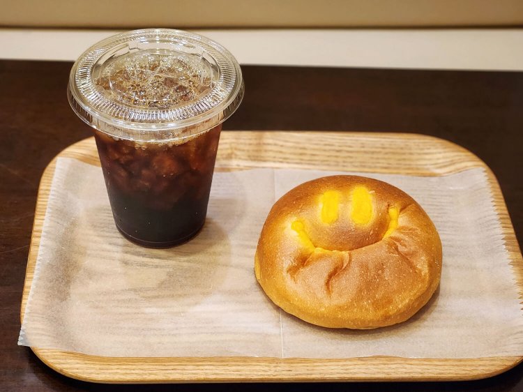 スペシャリティ アイスコーヒー テイクアウト432円（イートイン440円）、しあわせを呼ぶクリームパン テイクアウト238円（イートイン242円）。