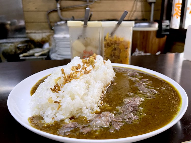 らっきょうと福神漬けとともにテーブルに運ばれてきた牛すじカレー。