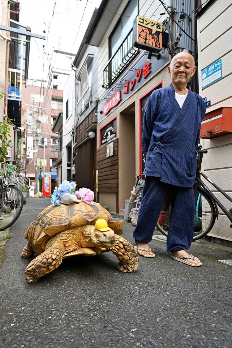 三谷葬儀社の三谷さんと愛亀のボンちゃん（27歳）は、ほぼ毎日お散歩。同社→新井建具店前→もんじゃストリートが定番コースだ。暑い日は17時ごろ、涼しくなると16時30分ごろが散歩タイム。