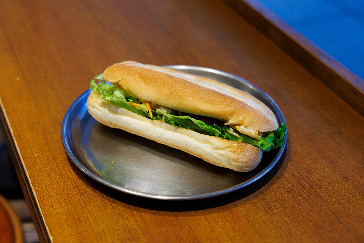 ベーコンエッグサンドイッチ450円。具材を鉄板で焼き、ほんのり甘めのソフトフランスパンでサンド。