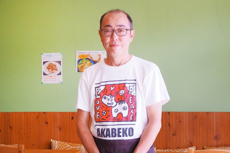 赤べこTシャツを着た社長の松尾さん。このTシャツも「東北基地エール」で販売している。