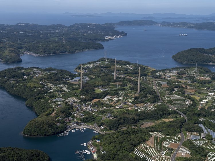 東側「西海パールライン」道路上空から塔を望む。背後は景勝地九十九島方向。視程の良い青空であったのが幸いし、佐世保湾の入江と島々が望めた。周りに高い建物がないため、塔の高さがひときわ目立つ。