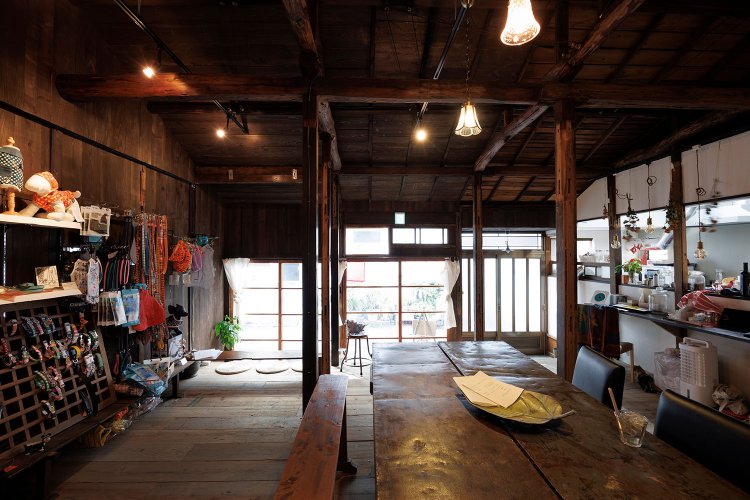 2軒長屋を貫いたカフェは、英国アンティークのテーブルも印象的。犬グッズのセレクトショップを兼ね、犬関連の本棚の本は自由に読みふけることも。犬連れ利用も歓迎だ。