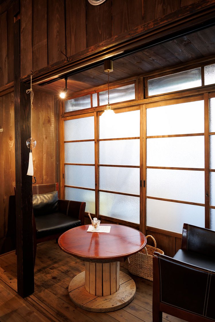 ガラスの引き戸が風情を醸す広縁に、ふかふかのイスと円卓を置いた2人席。店内を見渡せる特等席としても人気だ。