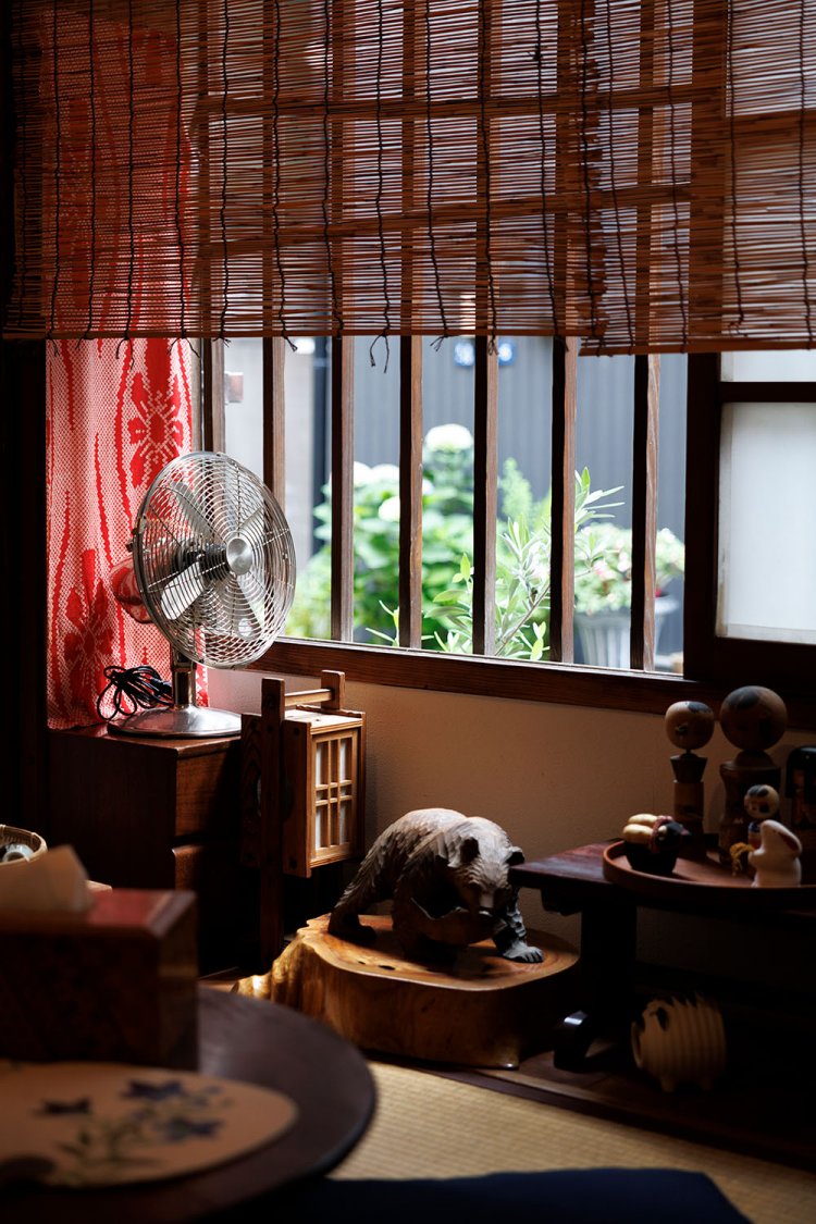 葭津（よしづ）を下げた2畳間。姿見に古い着物生地をリメイクした佐藤さんの母作のカバーをかけ、月島の長屋などから集まった民芸品も飾る。艶っぽさもまとう、妙に落ち着く場所だ。