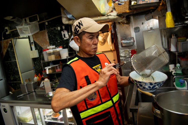 厨房を仕切るベテランシェフも、バイクタクシーのベストを着こなす。