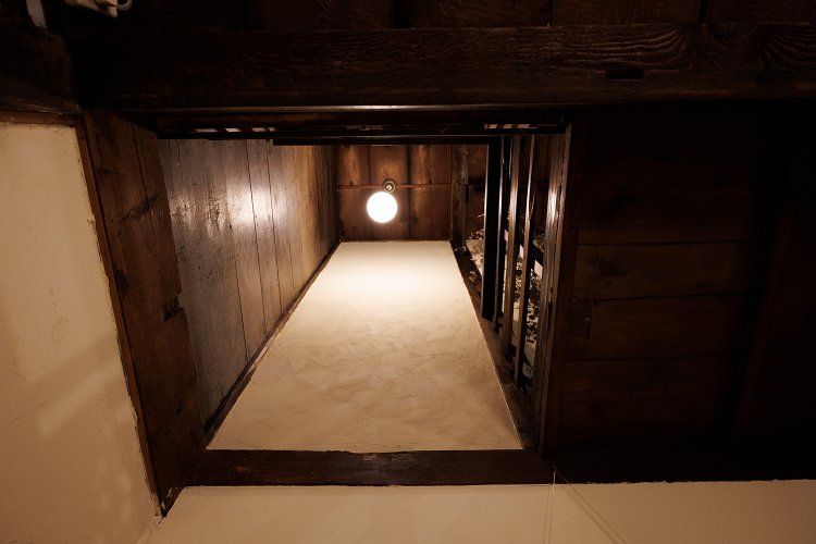 かつて物入れだった場所をテーブル席に変え、天井の一部を剝いで2階までの吹き抜けに。