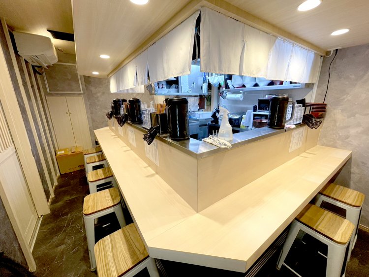 厨房を囲むようにコの字のカウンター席が並ぶ。まるでラーメン屋台のよう。