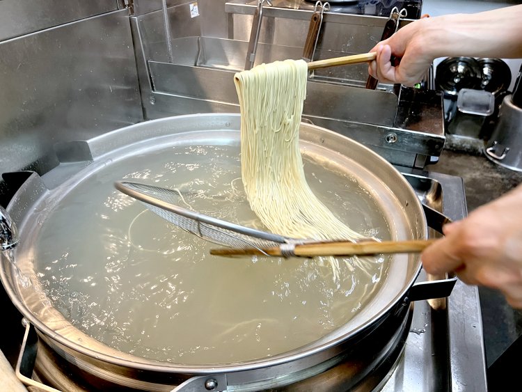 『柴崎亭』仕込みの麺揚げ。お湯の中で泳ぐ麺は織物のよう。