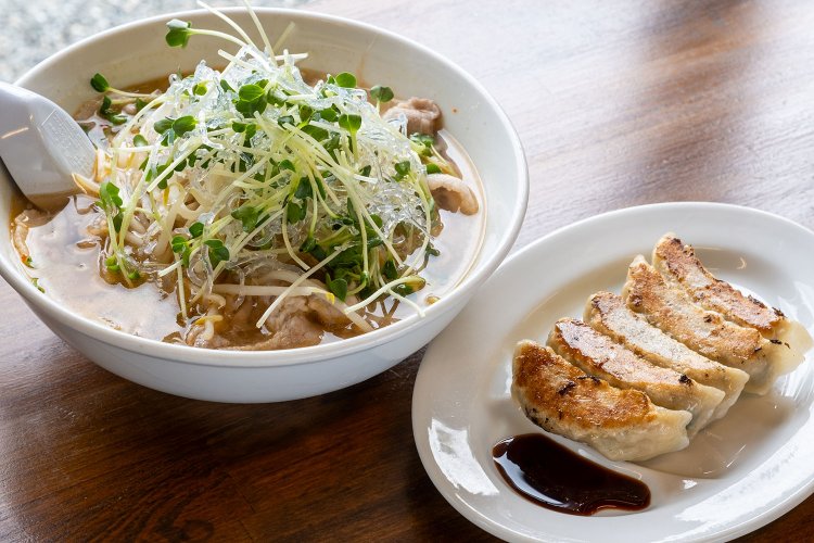 豚バラ肉入りの塩スープに、海水晶・カイワレ・モヤシがたっぷり盛られた中辛のコンパルラーメン850円（左）と餃子400円。