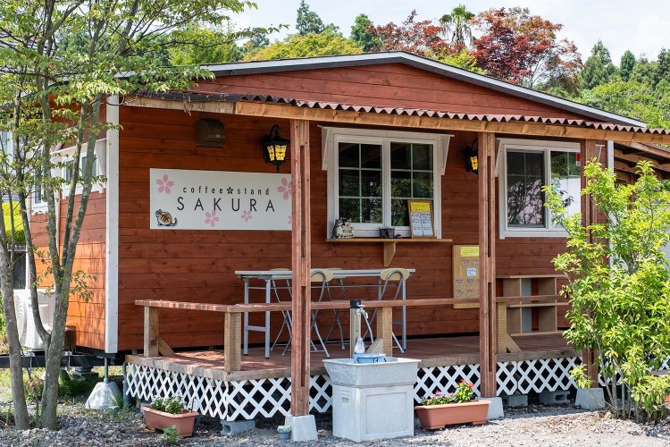 トレーラーハウスが原型のウッディな店舗。テイクアウトがメインだが、屋根付きのテラス席でくつろぐのもいい。