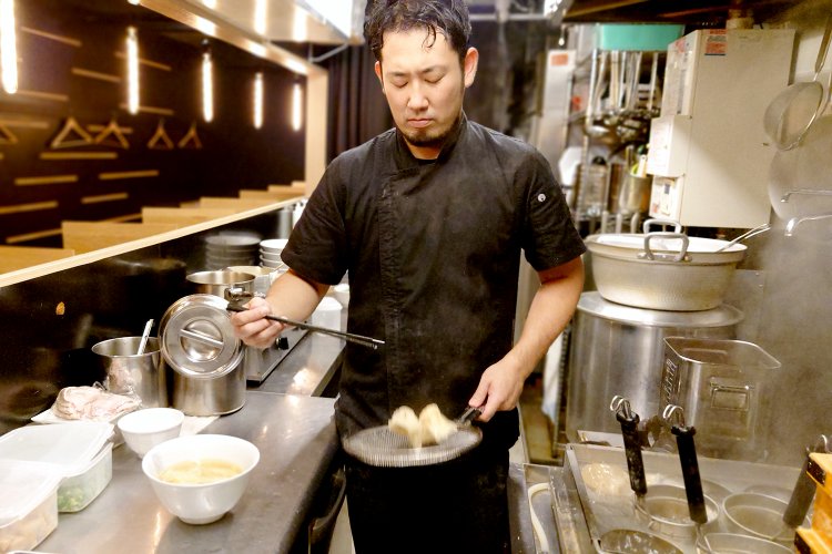 平ざるでワンタンの湯切り。跳ねるワンタンと澤田店主の所作にほれぼれ。