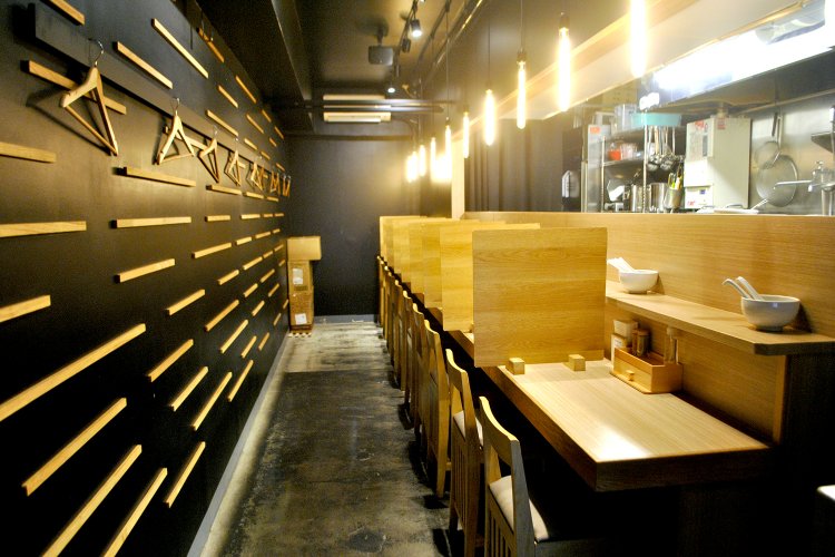 カウンター10席。黒い内装に木の飾りで広がりあるシックな空間。