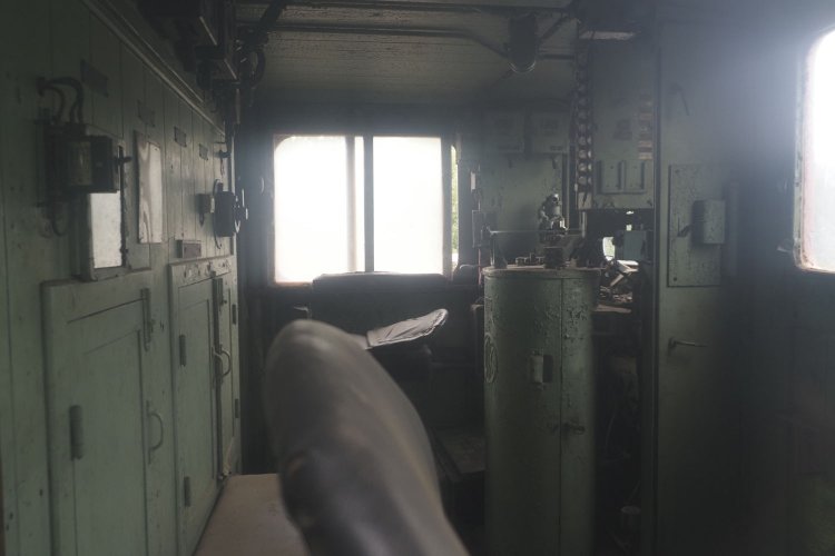 観賞用の通路から窓越しに運転室内を覗く。手前が機関助士の座席だ。機関士席は奥。