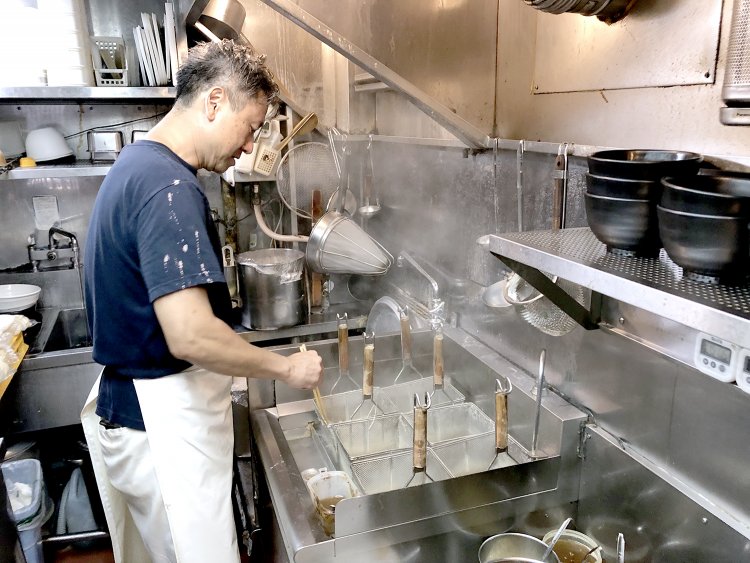 厨房に立つ店主の柳沼英次さん。