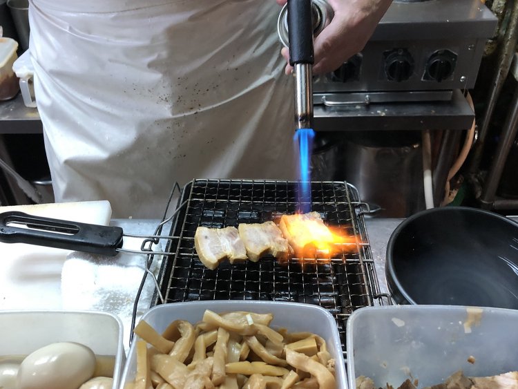 特製つけ麺用のチャーシューは、最後にバーナーで仕上げられる。