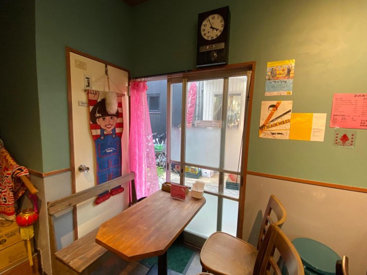 インパクトある黒柳徹子の壁掛けと、ピンクのレースカーテンが素敵にマッチしている。