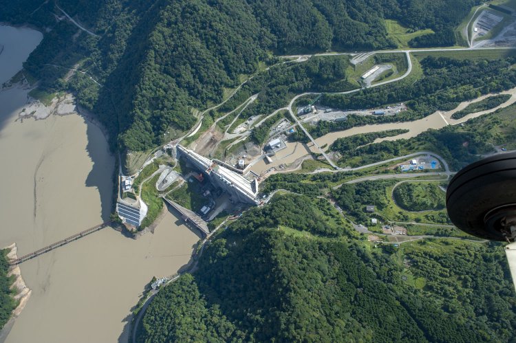 大夕張ダム（堤高67.5m）の下流側に建設中の夕張シューパロダム(堤高110.6m)と、堤体の規模が一回り大きい。なお右端の車輪は撮影機（セスナ機）の車輪である。