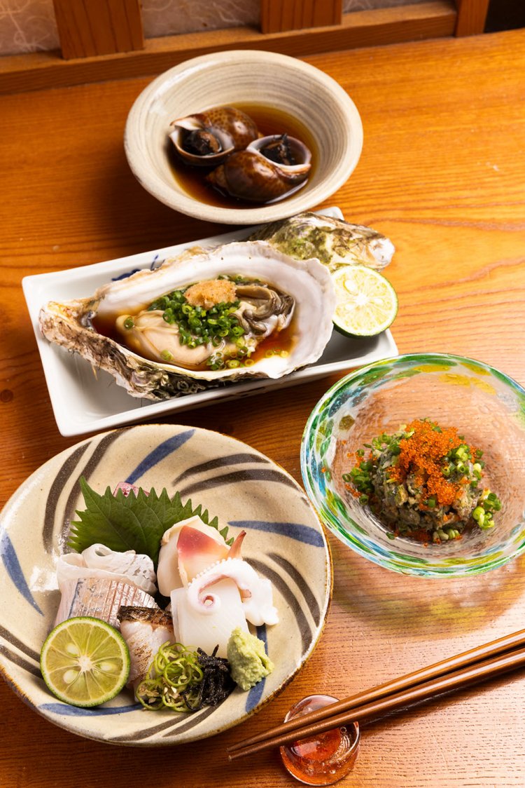 おまかせコース5000円一例。お造り、イワシのなめろう、生ガキ、バイガイのうま煮と、どれも素材の味が澄んでいる。