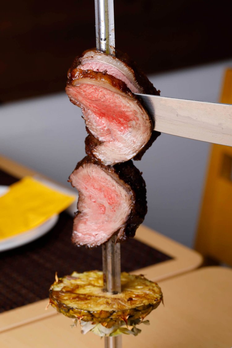 串刺し肉を席で切り分ける豪快さがシュラスコの魅力。