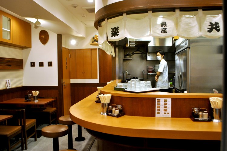 カウンター8席、テーブル4人席の計12席。厨房と客席が近く、アットホームな雰囲気は建て替え前と変わらない。